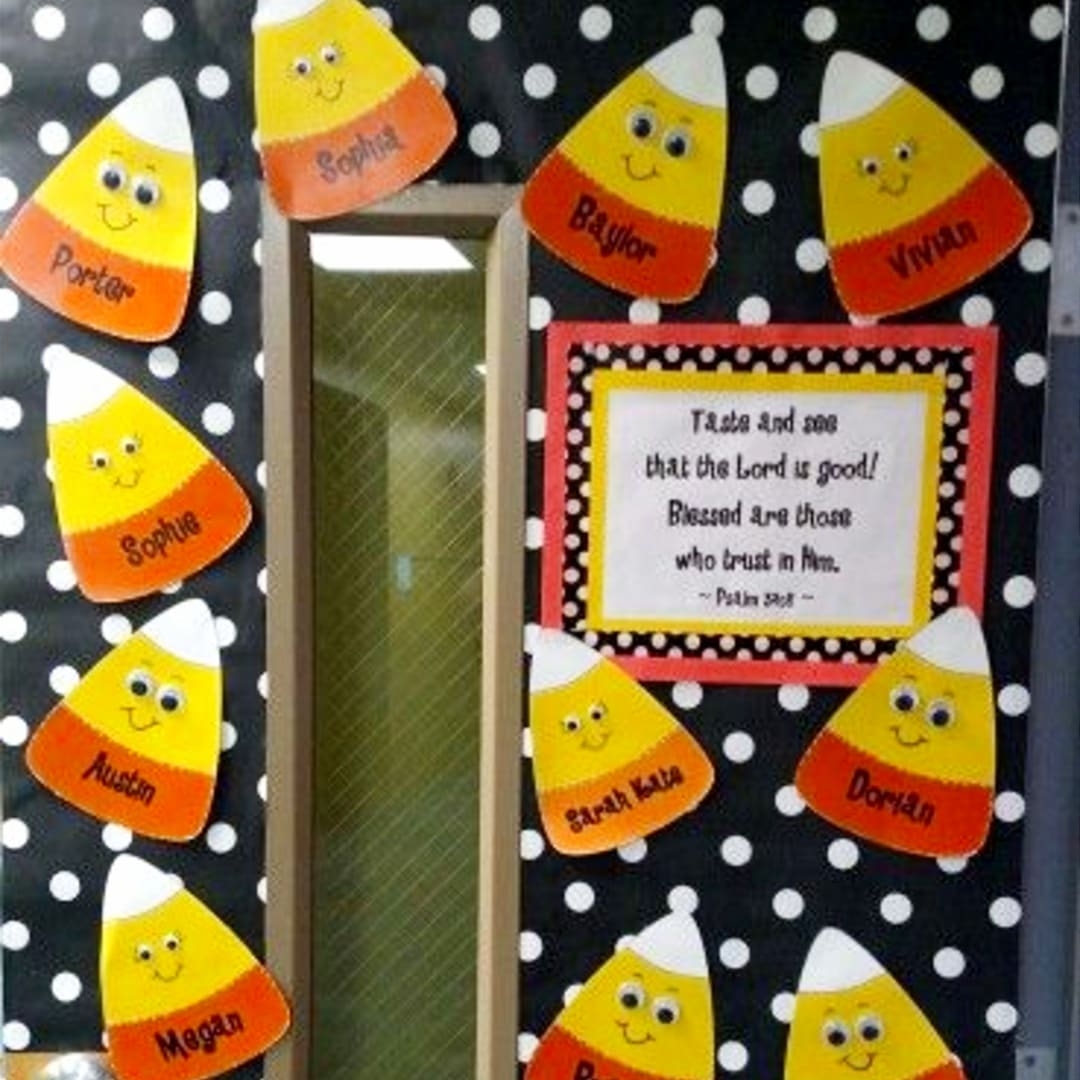 Fall theme classroom door bulletin board decorated with candy corn art work with students names found in church preschool classroom and Sunday School room