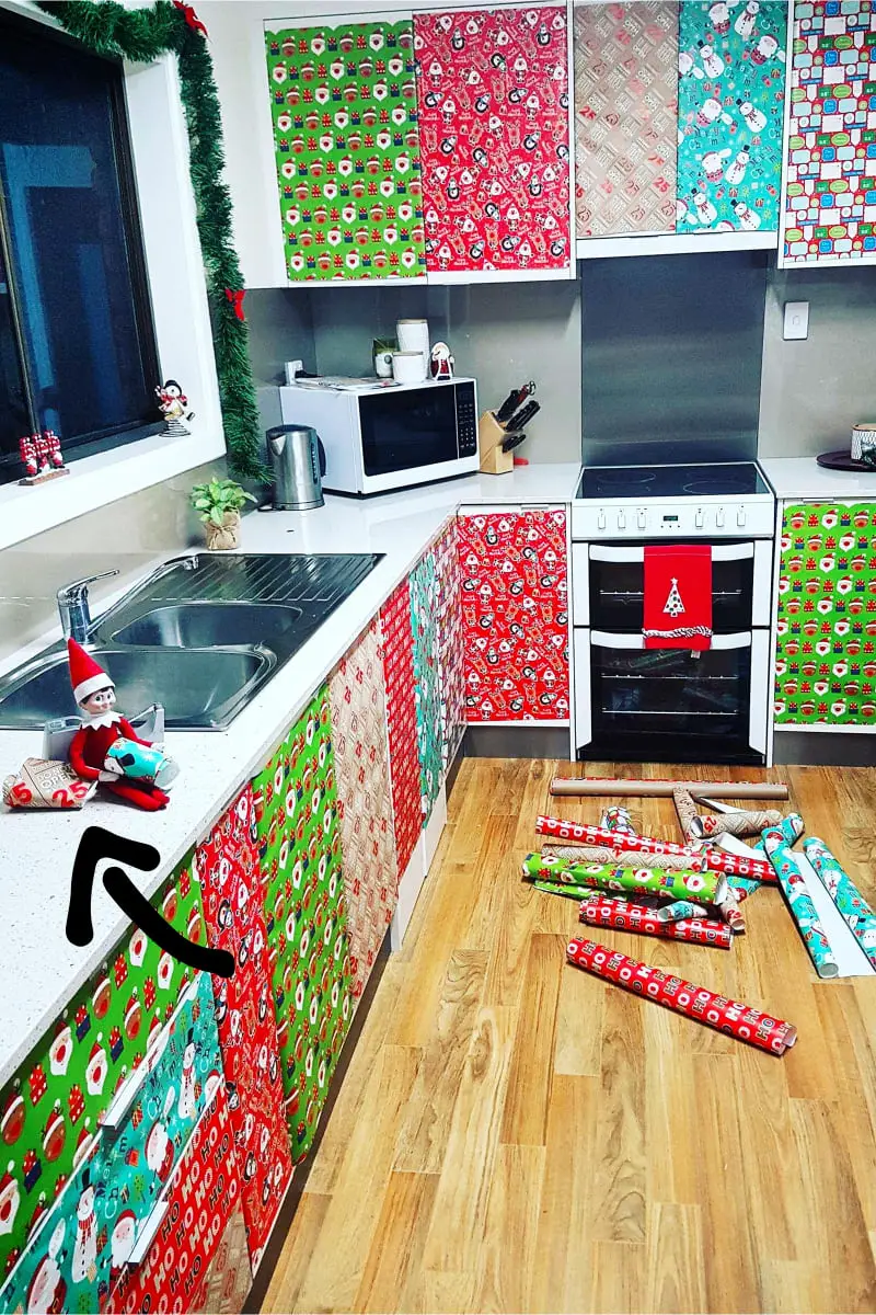 Elf on the shelf prank - naughty elf covered all the kitchen cabinet doors with wrapping paper
